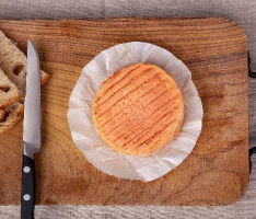 planche en bois avec un fromage et un couteau